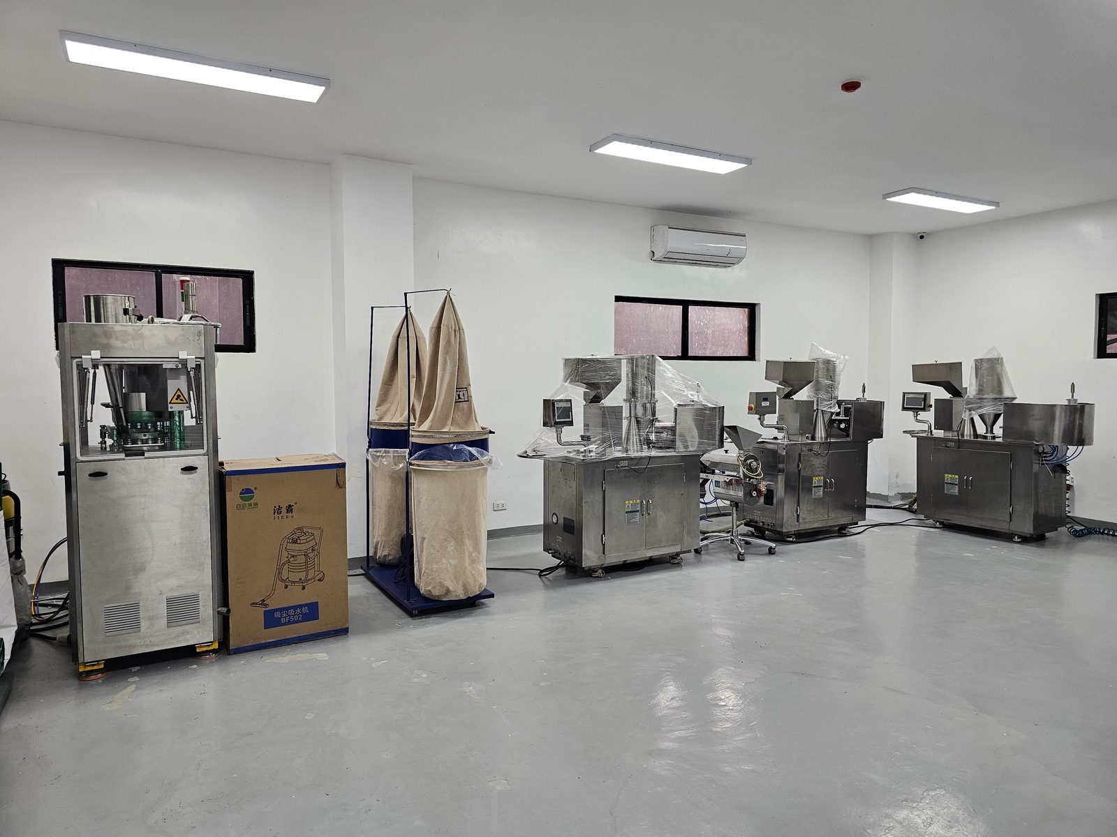 Row of capsule-filling and encapsulation machines on the production floor